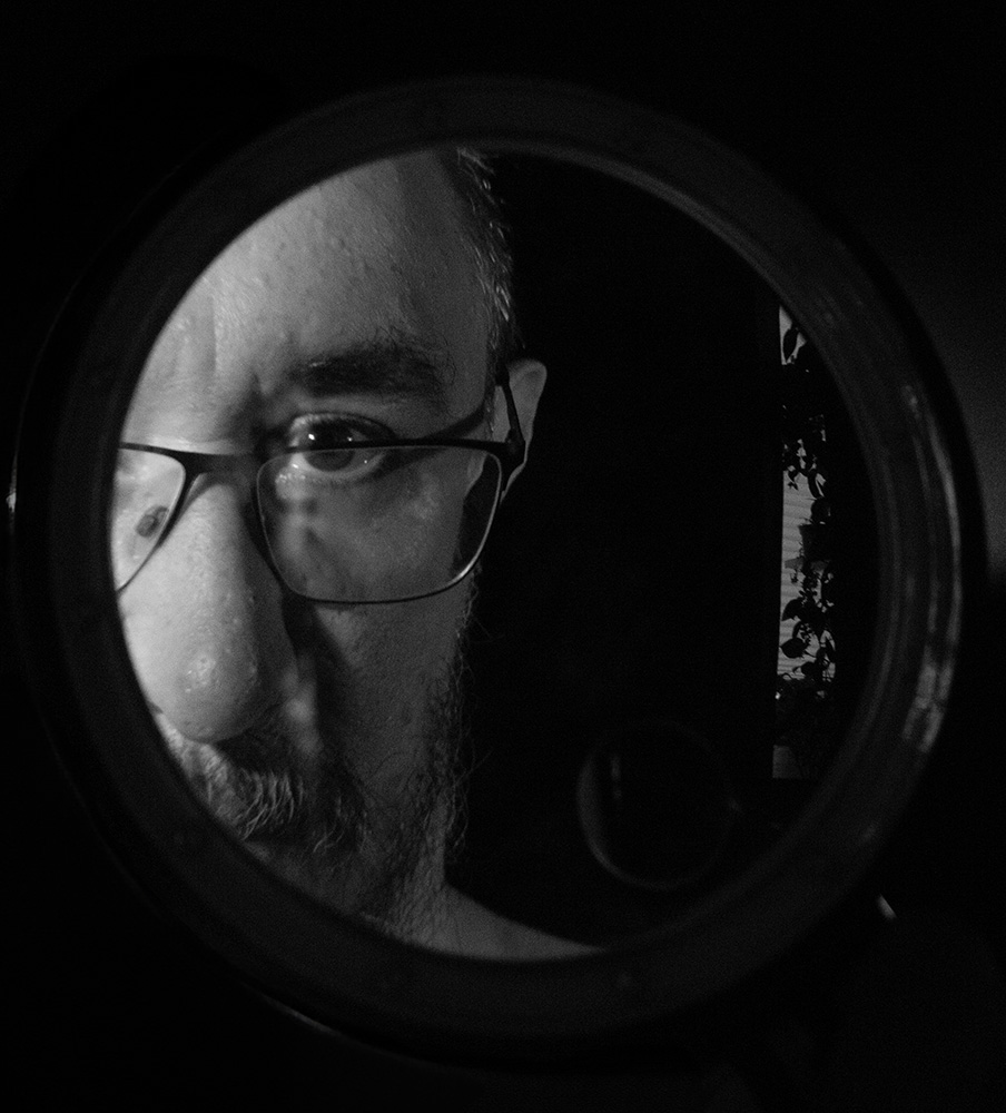 Self portrait of the photographer behind Rebel Shutter, black and white, vintage lens aesthetic
